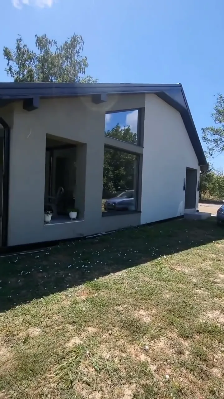 Završena fasada moderne kuće u sivoj nijansi, pogled sa travnjaka